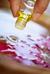 essential oil being applied to water with plant petals